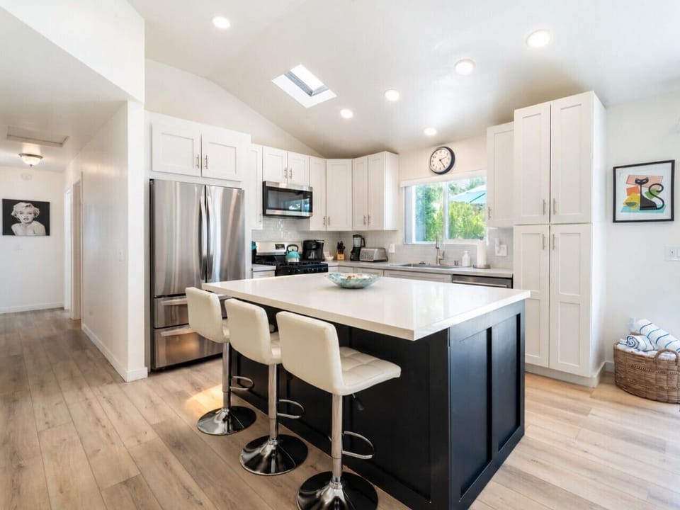 Kitchen features an island bar top and modern appliances.