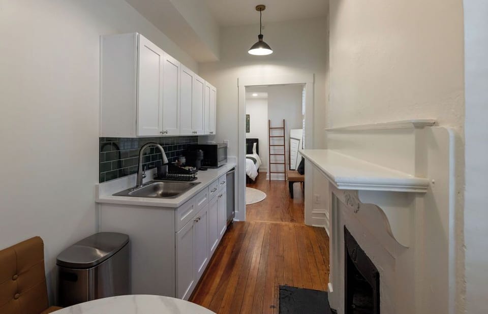 Charming kitchenette with hardwood floors and classic fireplace detail