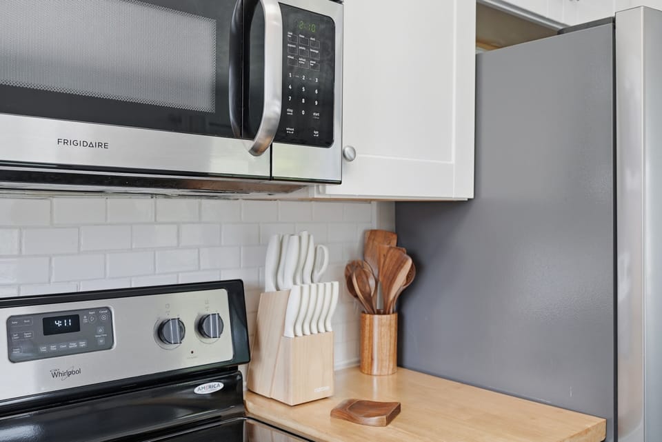 Modern kitchen with stainless appliances and warm butcher-block counter