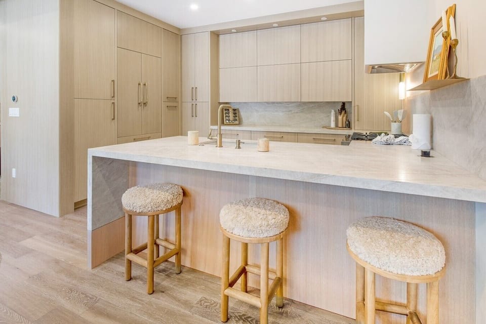 Perch at the island while someone cooks in the beautifully renovated kitchen. Fresh cabinets, room to spread out, and a space that invites everyone to linger.