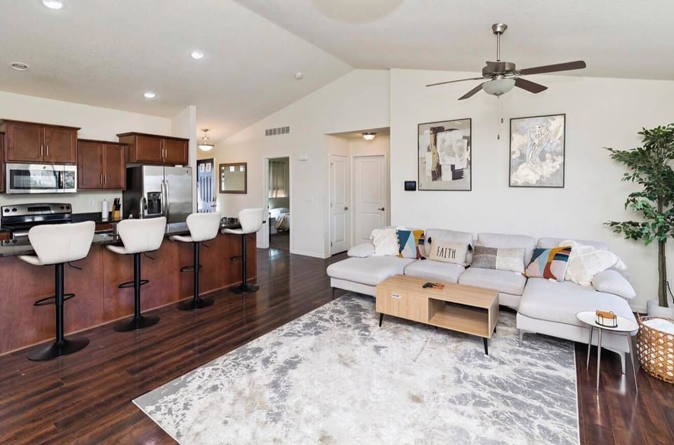 Bright open living space with vaulted ceilings and breakfast bar seating
