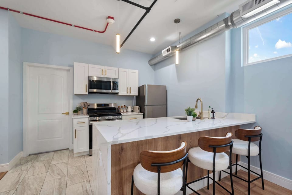 Sleek kitchen island w/ bar stool seating, perfect for casual meals.