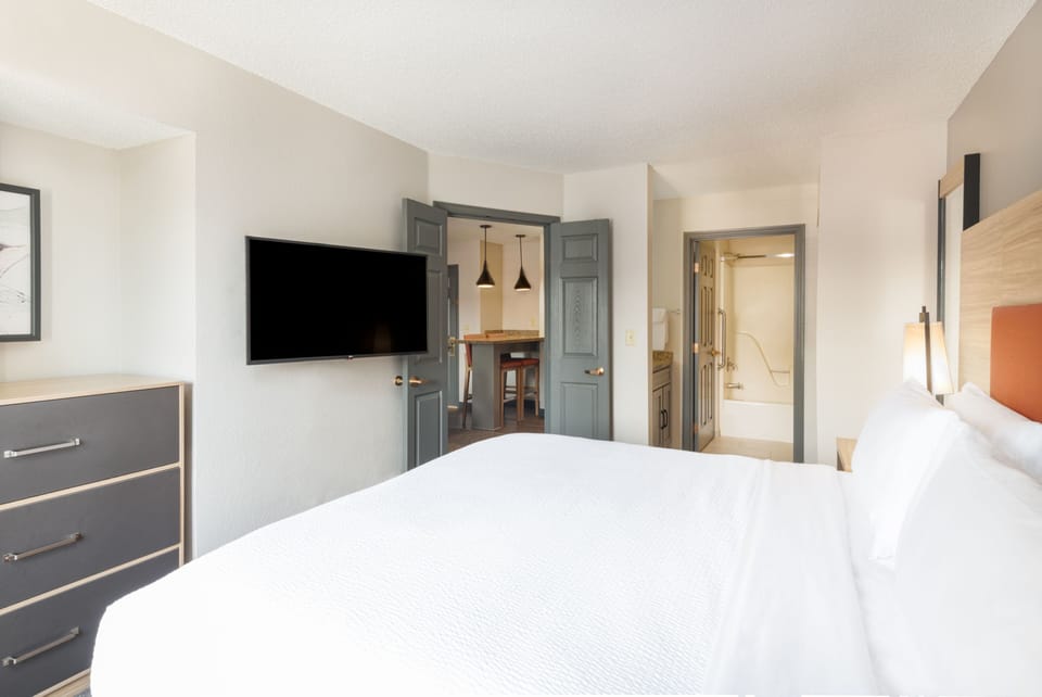 Cozy bedroom with modern decor and flat-screen TV.