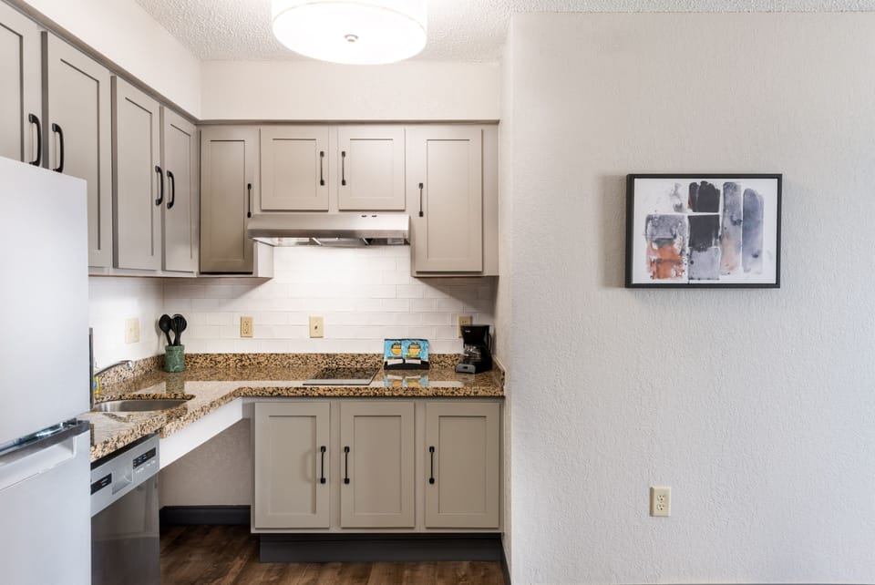 Modern kitchen featuring gray cabinetry and granite countertops.