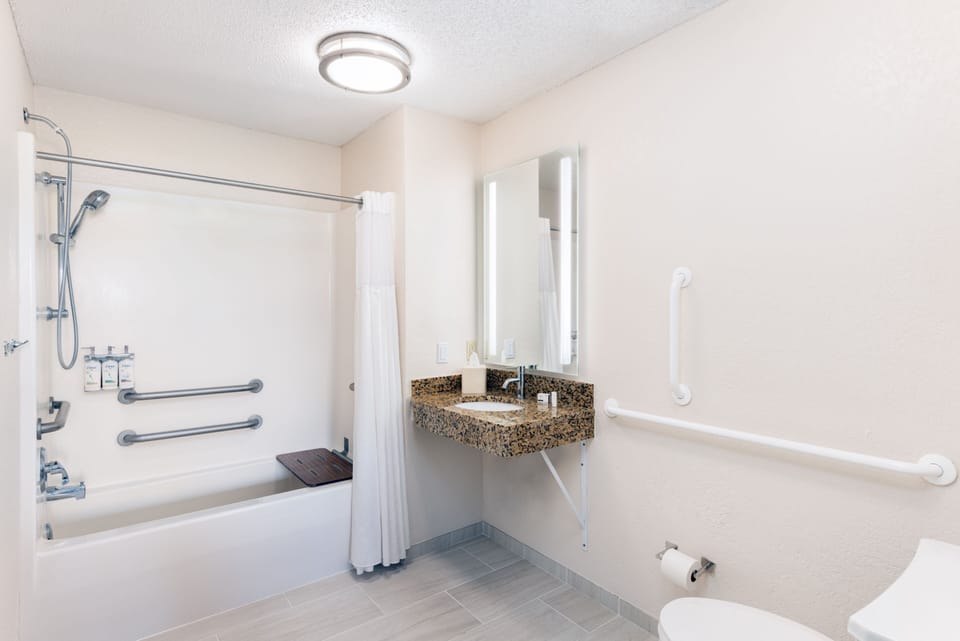 Accessible bathroom with shower-tub combo and grab bars.