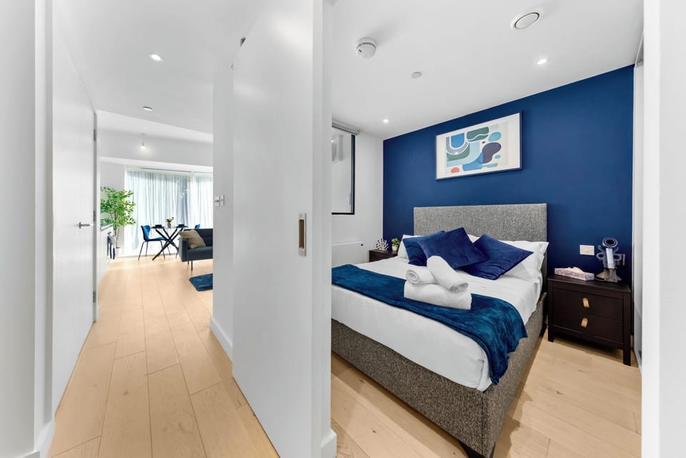 Modern bedroom with bold blue accents and sleek open-plan flow