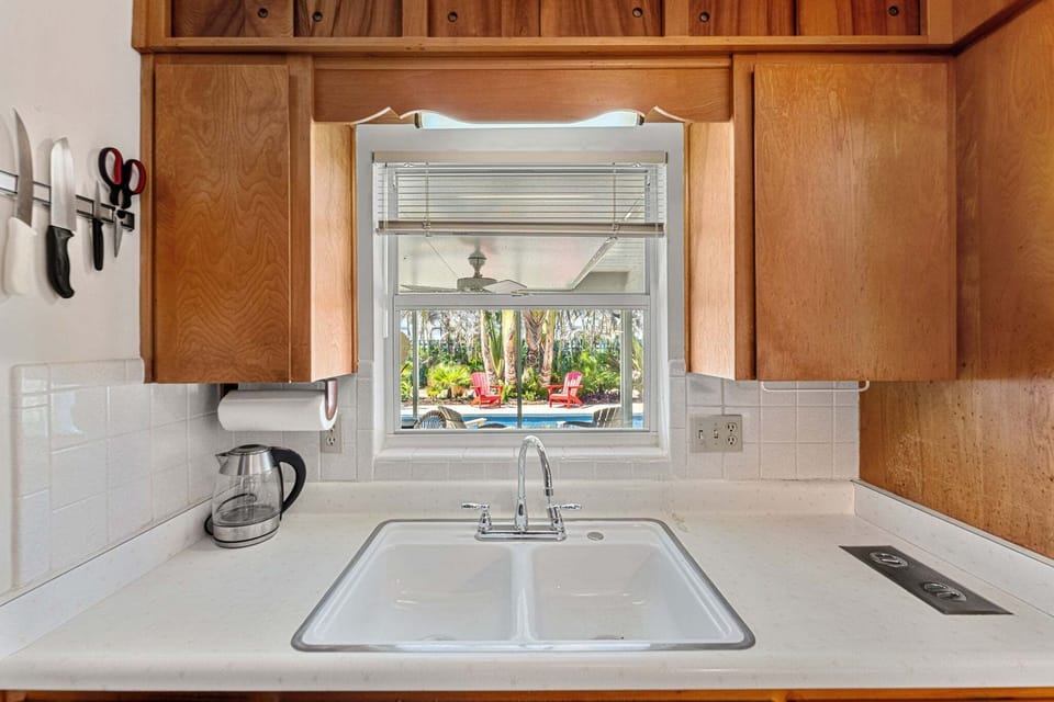 The kitchen sink overlooks the outdoor patio and pool