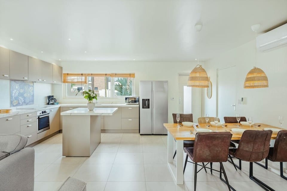 Cook and gather with ease in the fully equipped kitchen, complete with a spacious island, full-size appliances, and a dining table for shared meals.