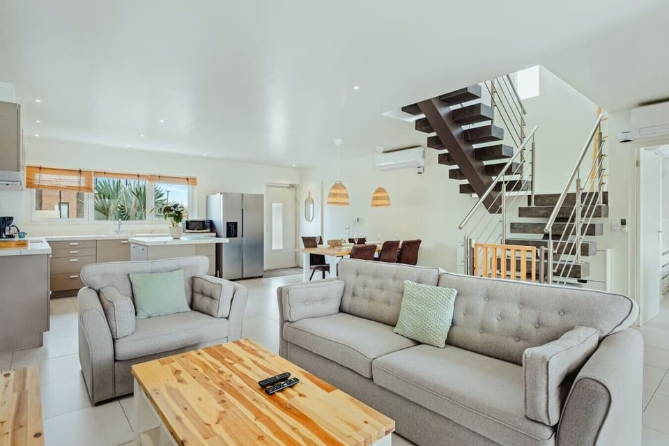 The open-concept living area brings everyone together with comfortable seating, a fully equipped kitchen, a dining space, and easy access to the upper floor.