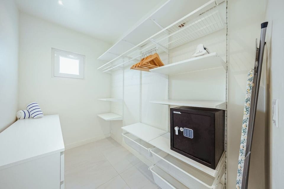 The walk-in closet offers plenty of space to unpack, along with hangers, a safe, and an iron for added convenience.
