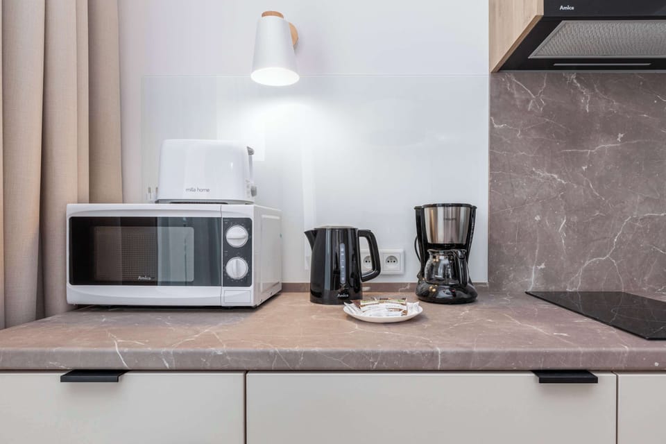 The kitchen's sleek design includes all necessary cookware and utensils. 