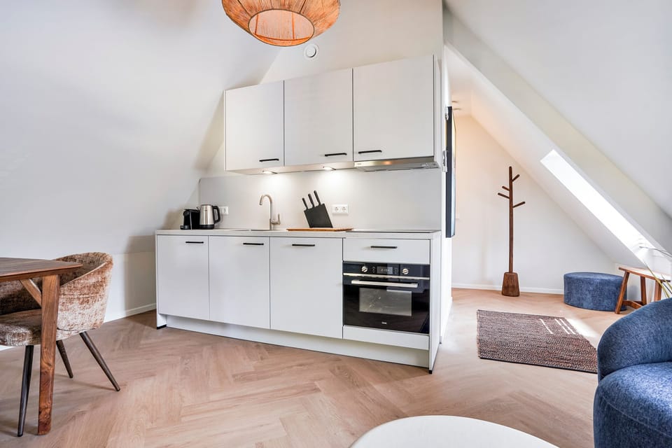 Modern private kitchen with an oven, induction cooktop, coffee machine, kettle, and everything needed for home-cooked meals.
