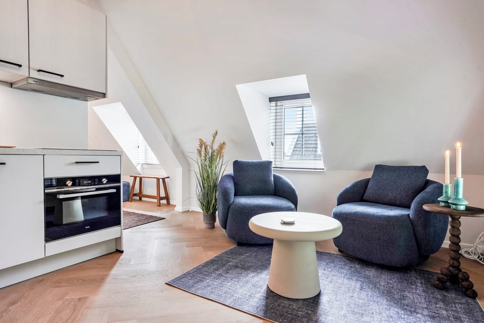 Spacious living area with comfortable seating, Smart TV, air conditioning, and a fully equipped kitchen just steps away.