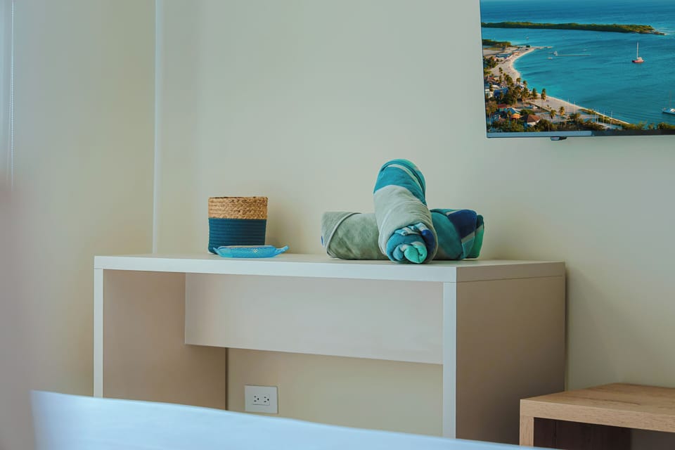 Fresh towels in coastal shades are rolled and ready for your arrival, alongside a guide to local hidden gems that hint at the paradise waiting nearby.