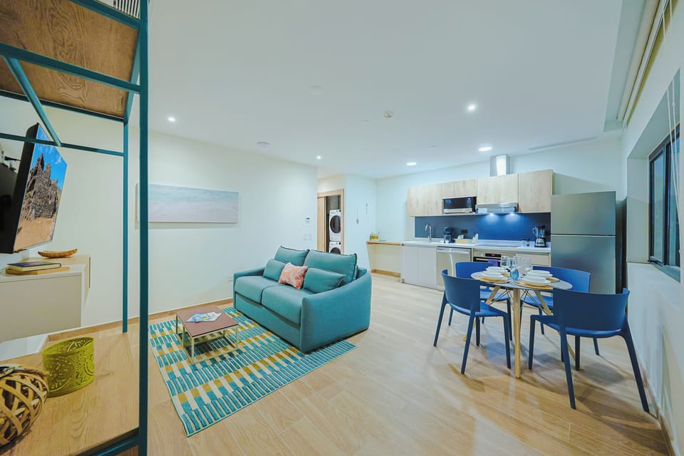 Step into your private open-plan retreat with modern touches and calming coastal hues. Relax in the cozy living area or gather around the dining table for a meal.