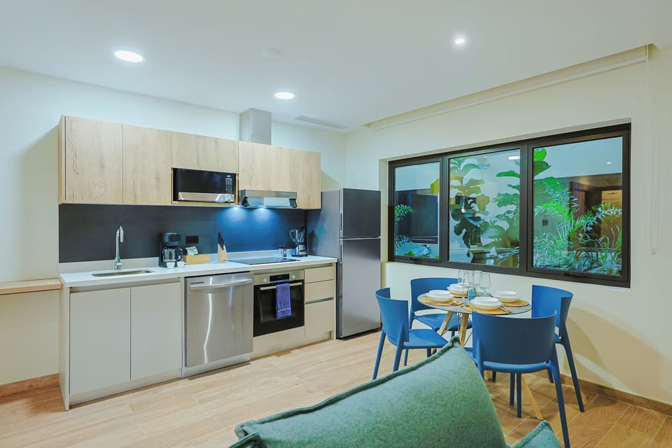 Step into your modern, fully equipped kitchen and dining space, where you'll find everything you need to prepare meals while enjoying garden views through the wide windows.