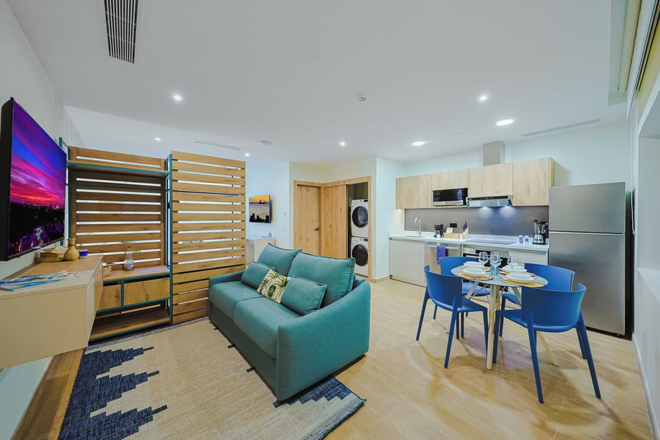 Your spacious open-concept retreat seamlessly blends living, dining, and kitchen spaces with contemporary comfort and vibrant pops of color throughout.