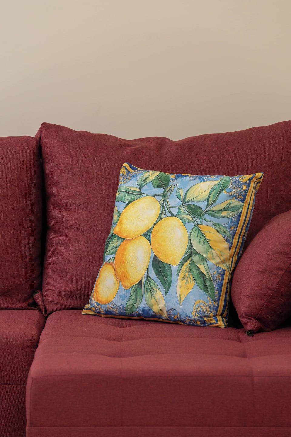 A close-up of a red armchair featuring a colorful patterned cushion, highlighting the warm and decorative details of the seating area.