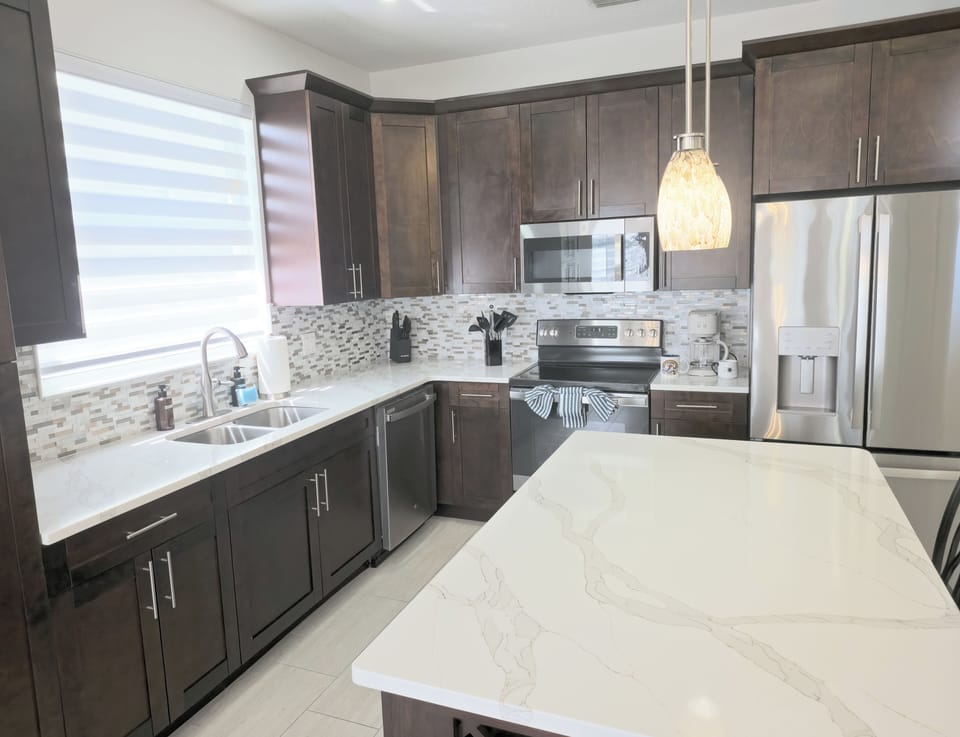 Modern chef's kitchen with quartz island and stainless appliances