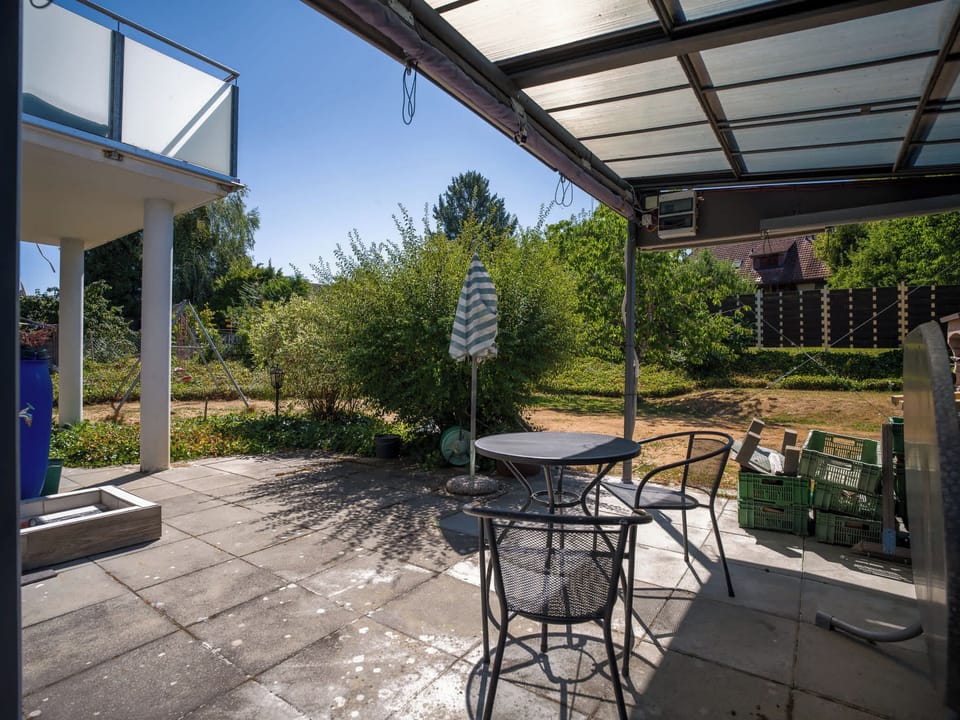 Covered balcony seating area for enjoying fresh air outdoors.
