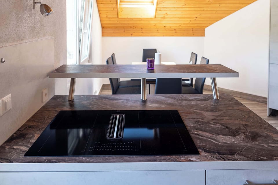 Modern kitchen island with stovetop and dining space nearby.
