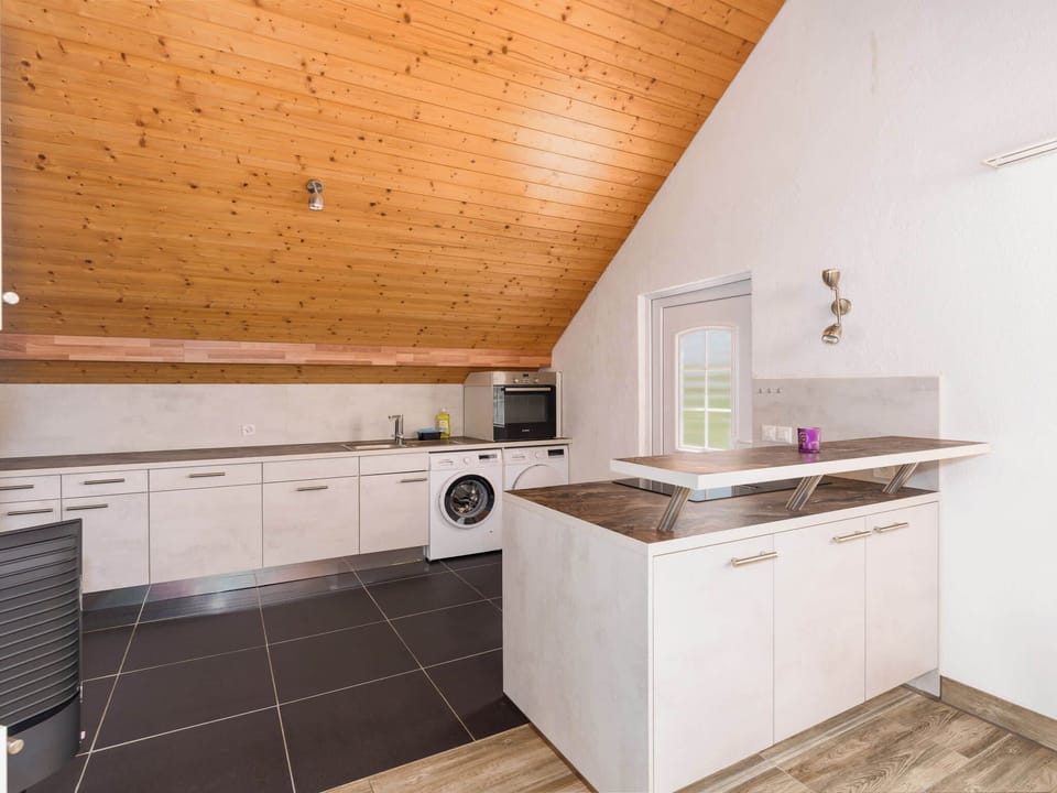 Modern open-plan kitchen with practical workspace and everything needed for preparing meals.
