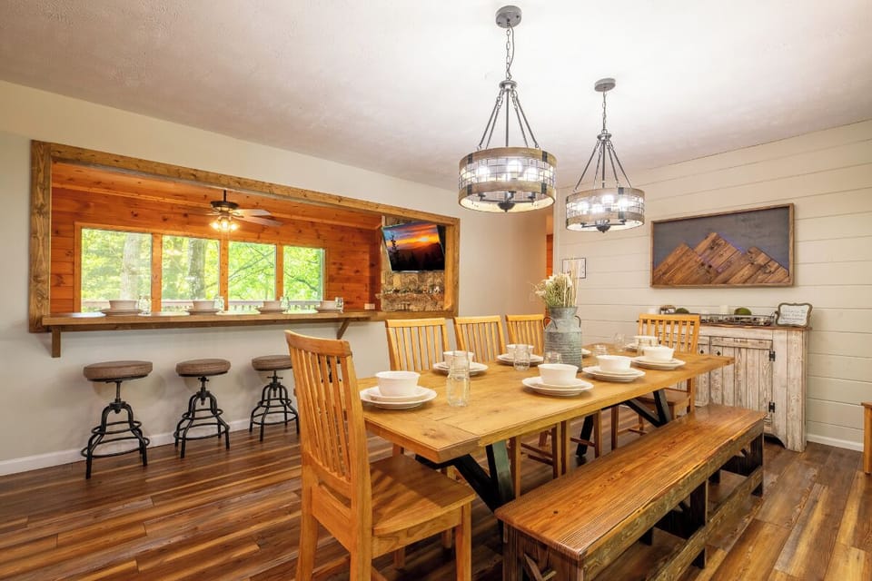 Gather around the spacious farmhouse table where family meals and laughter flow easily. Sunlight streams through the pass-through window, warming the rustic wood details.