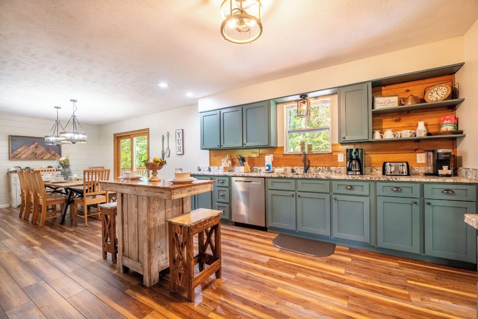 Your open-concept kitchen and dining space awaits with rustic charm and modern comforts. Gather around the island for morning coffee or linger over shared meals at the farmhouse table bathed in natural light.
