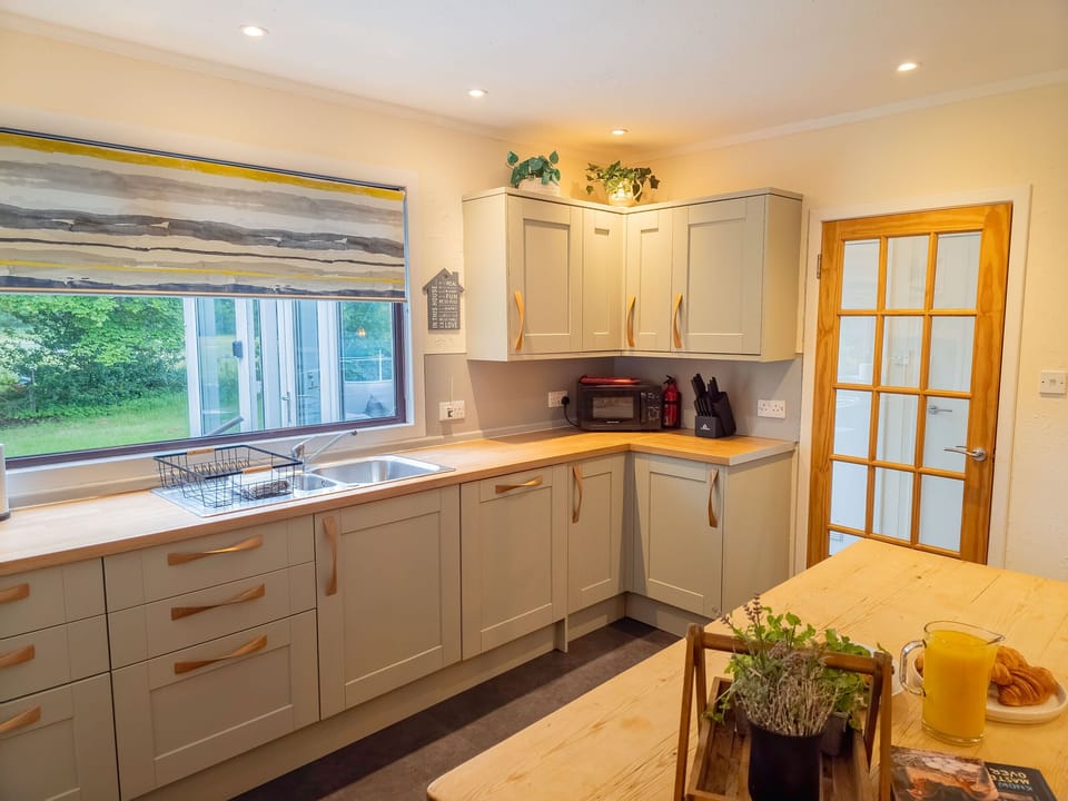 The sink sits under the window, so the washing up comes with a view of the garden. Plenty of worktop either side for cooking.