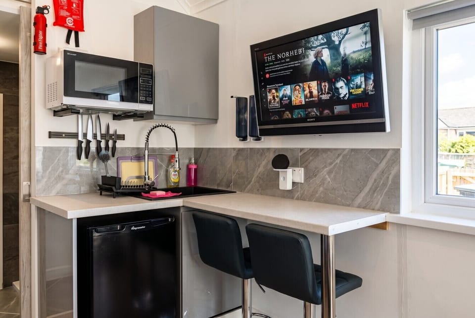 Kitchenette with Netflix-ready Smart TV and breakfast bar by the window.