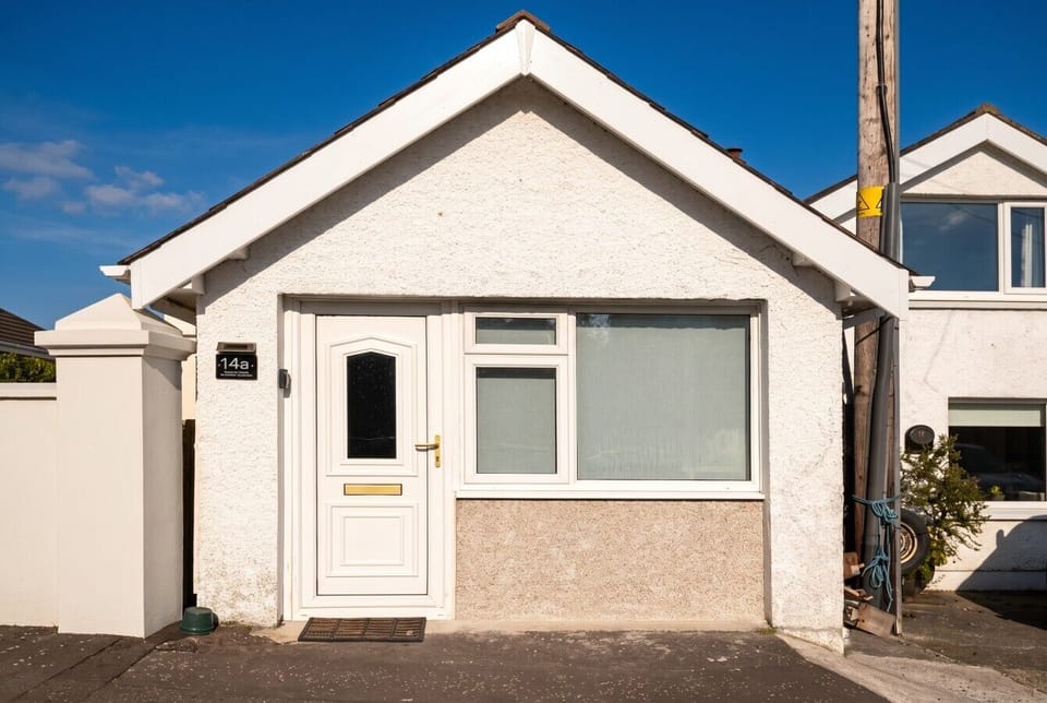 Charming whitewashed cottage exterior, your seaside home base.