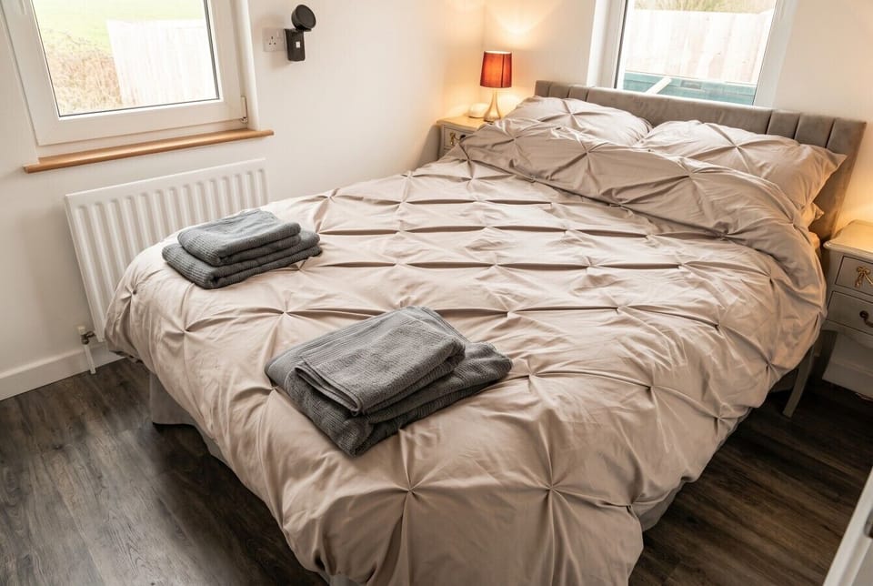 Sink into crisp linens with fresh towels and soft countryside light