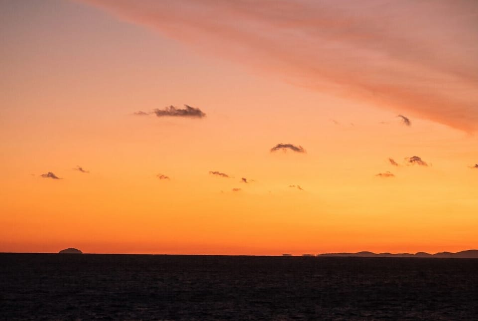 Fiery skies close out the day over a calm horizon