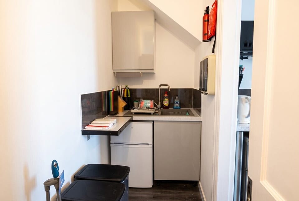 Tidy kitchenette corner with fridge and prep space