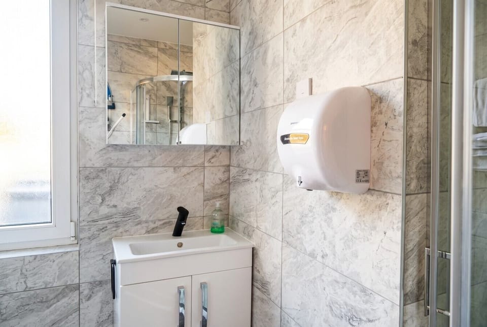 Clean marble bathroom with mirror and walk-in shower