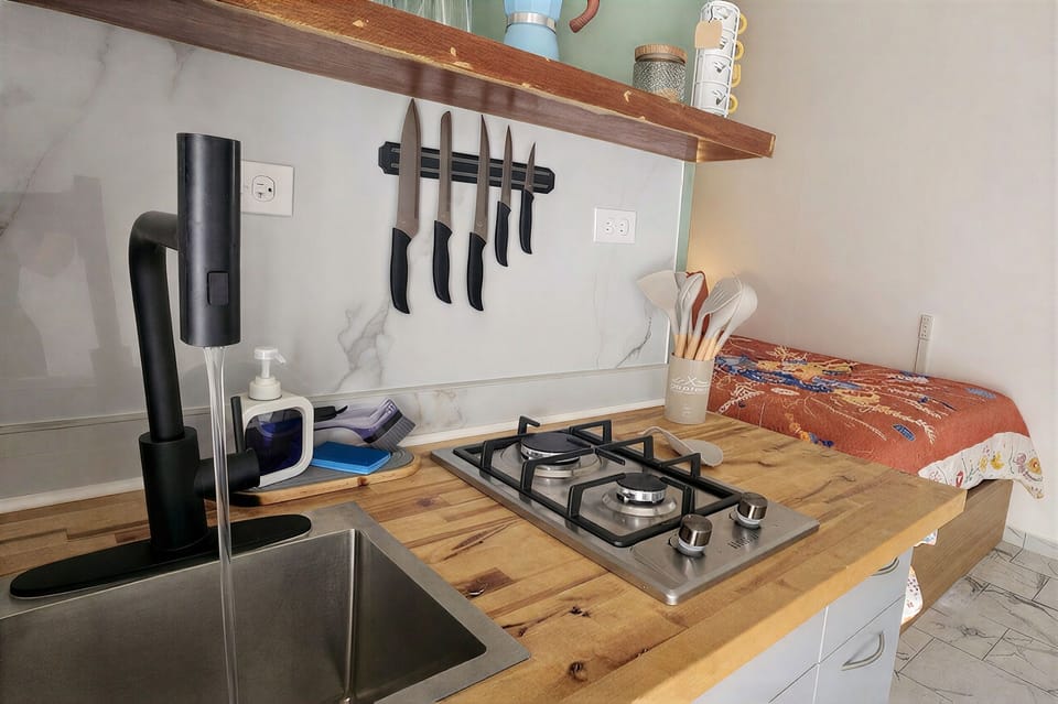 Cozy modern kitchen with wood counters, gas cooktop, and stylish open shelving