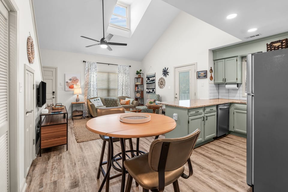 Bright open living area with skylight, stylish kitchen, and cozy seating
