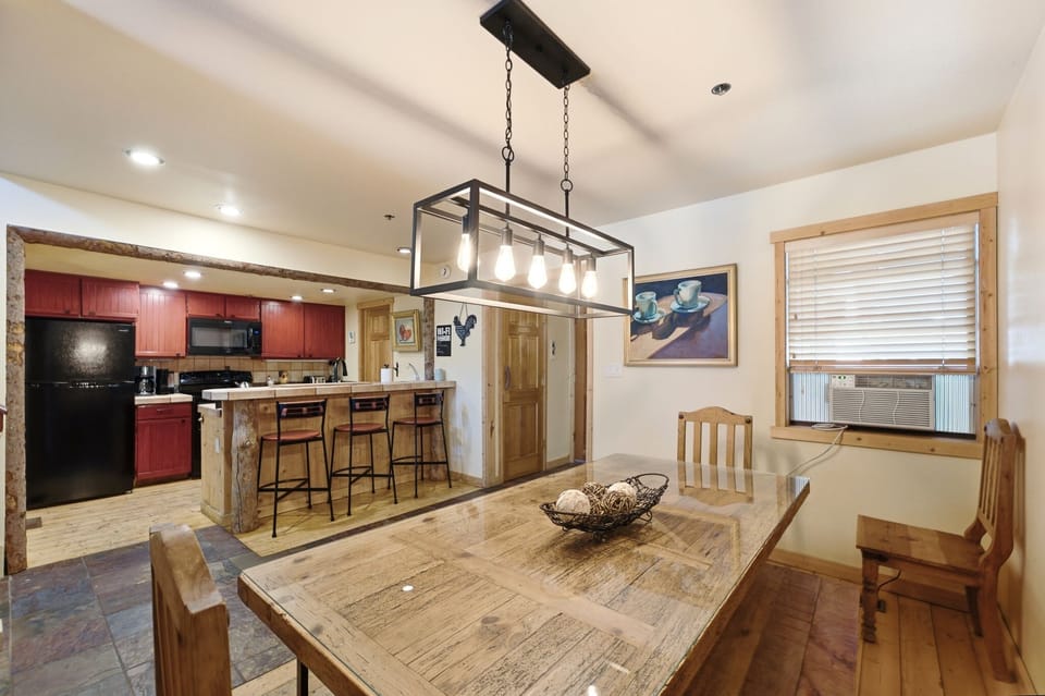 This warm dining space offers ample seating at the main table plus three barstools at the kitchen counter