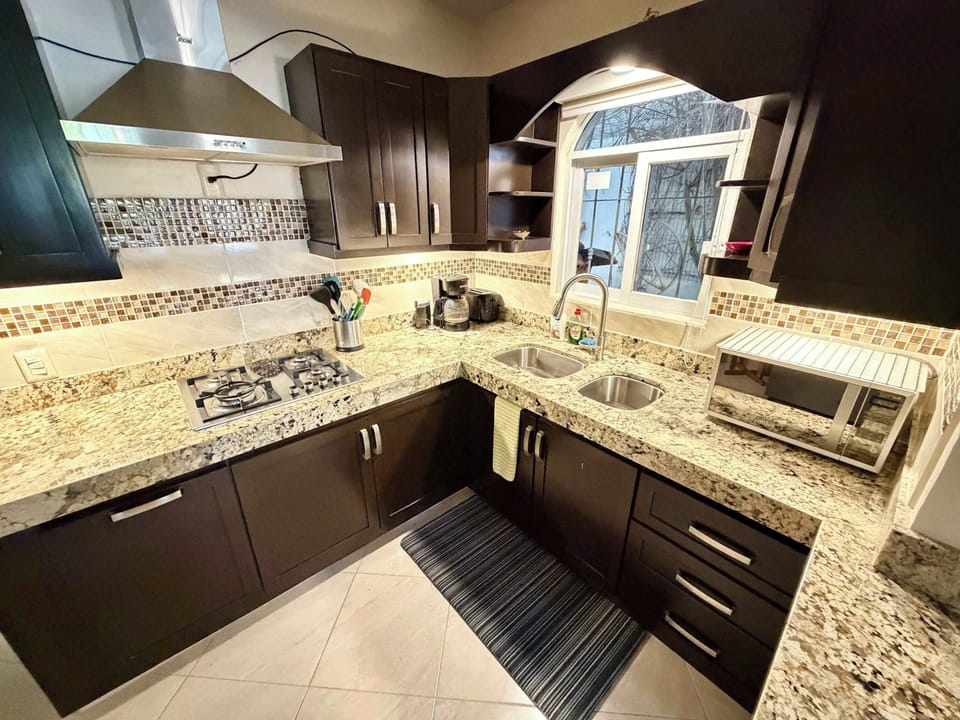 Full modern kitchen with marble countertops.