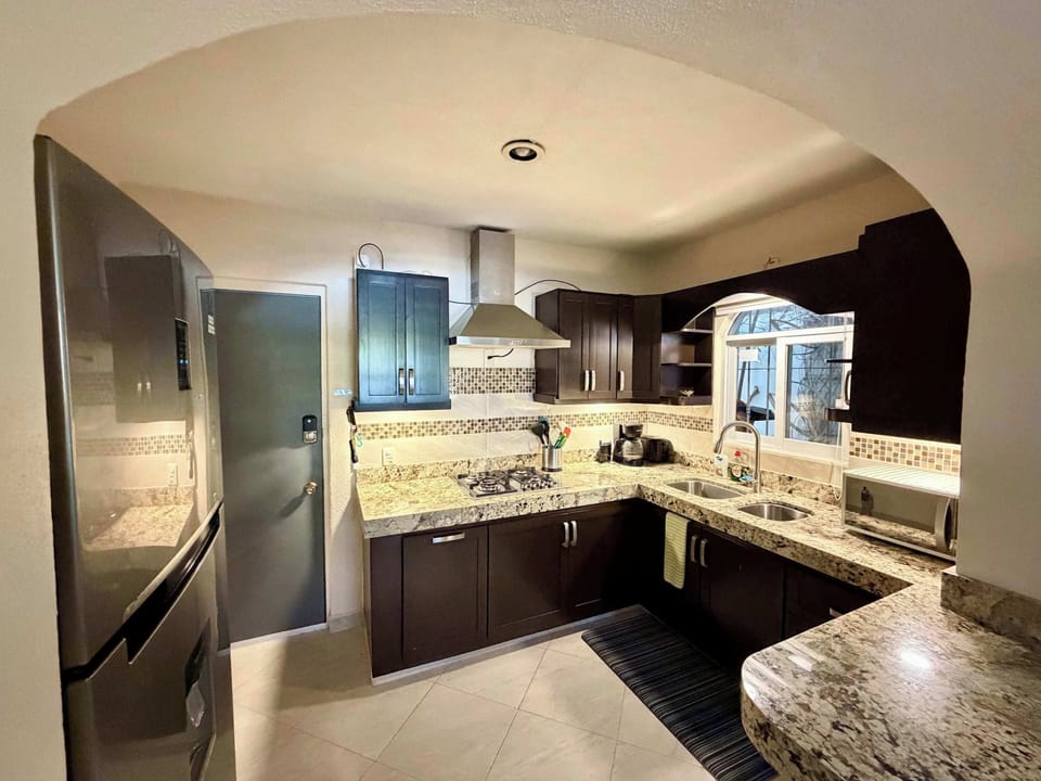 Modern kitchen with fridge, microwave, coffee maker, coffee grinder, blender, etc.