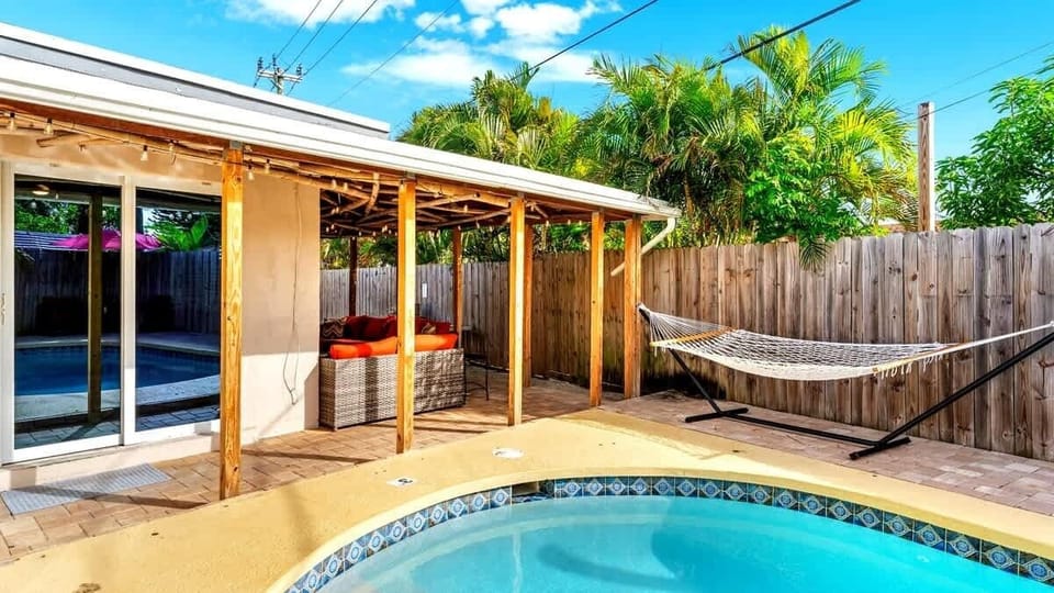Serene poolside view with a cozy hammock, ideal for unwinding and enjoying the peaceful surroundings.