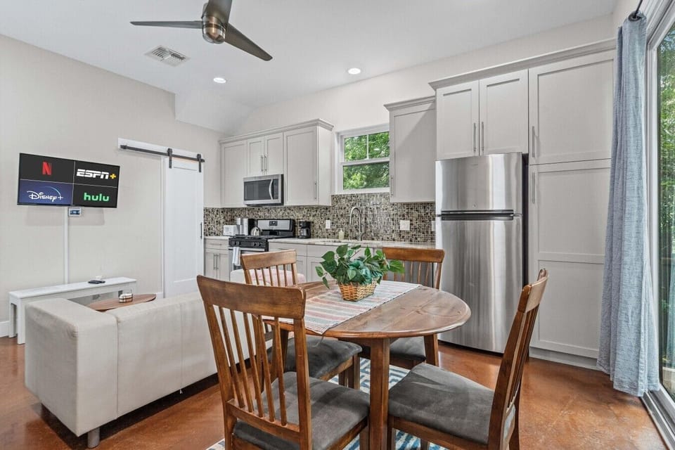 Dine in comfort with a Smart TV, stainless appliances, and a ceiling fan overhead.