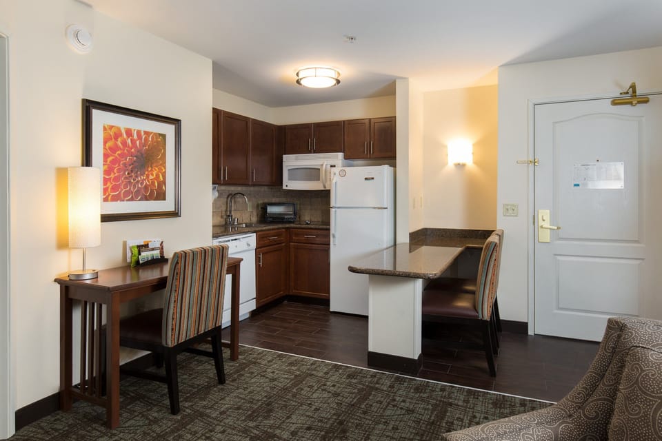 Desk workspace with task lighting, seating, and direct access to the kitchen behind