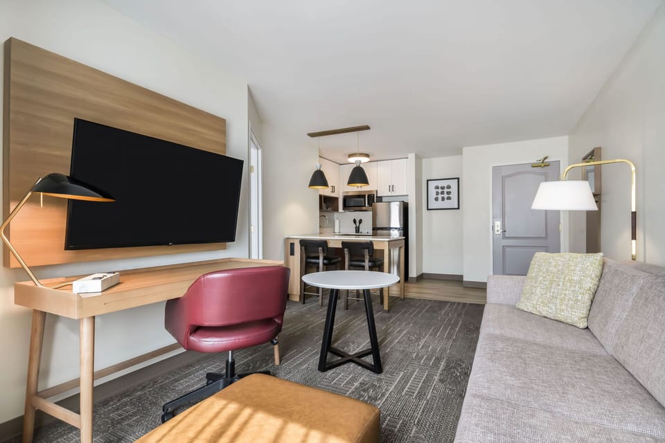 Open-plan layout with living area, dining table, kitchen, and desk all in one connected space
