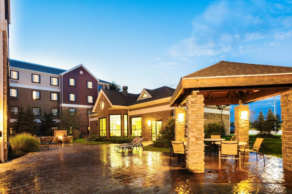 Outdoor patio with chairs, tables, a fire pit, and a BBQ area for evening gatherings