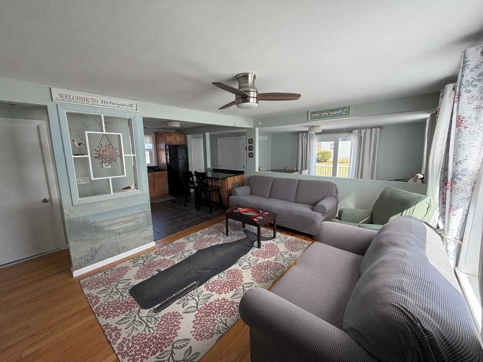 Living room with couch and chair and loveseat with open to kitchen and dining 