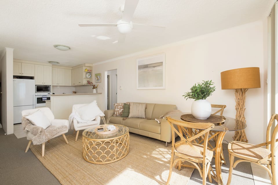 Bright coastal-style living space with open kitchen and sunny dining nook
