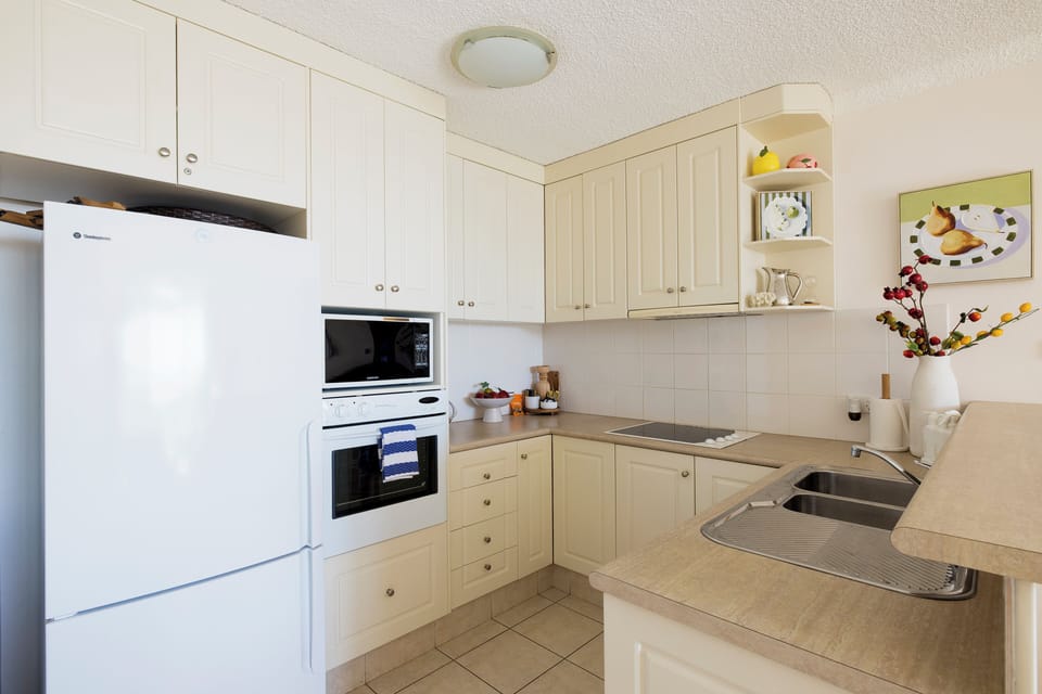 Bright full kitchen with ample storage, double sink, and clean modern layout
