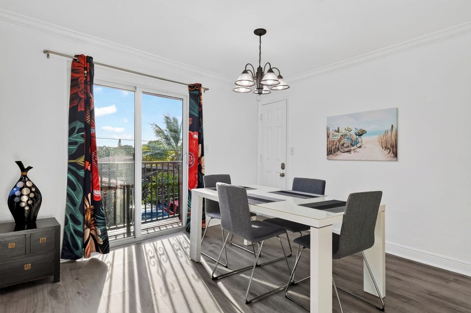 Dining area for four with balcony access and bright natural light.