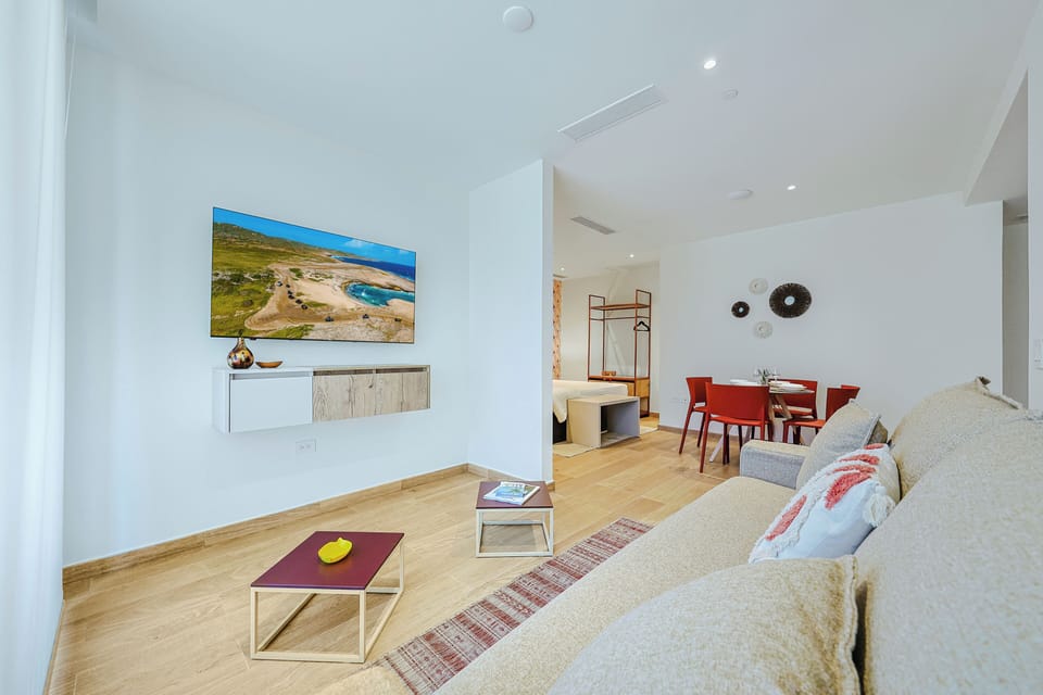 Your bright, open living space flows seamlessly into a dining area, offering a modern retreat with warm wood floors and clean, inviting design. Perfect for unwinding after a day of exploring.